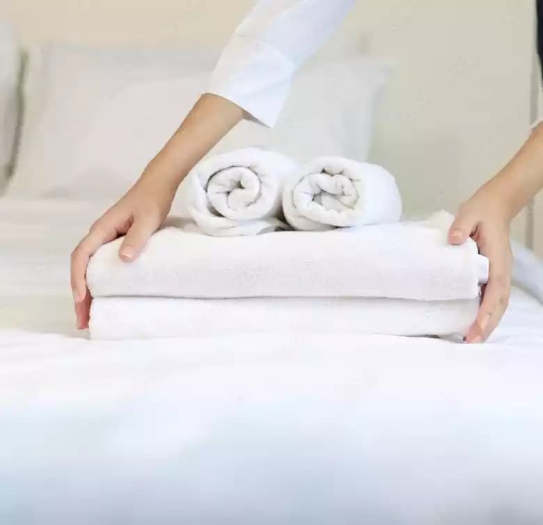 Hotel bed made with white linens